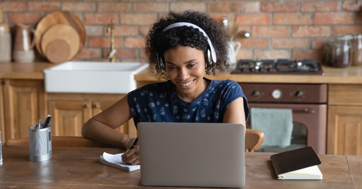 woman on laptop with headphones in doing an online course